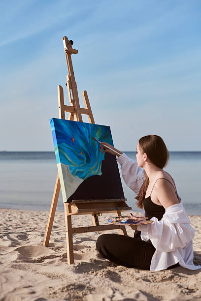 istock Young female painter creating art by beach 2227354940