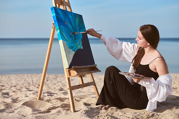 istock Female painter creating art on canvas by seaside 2227354984