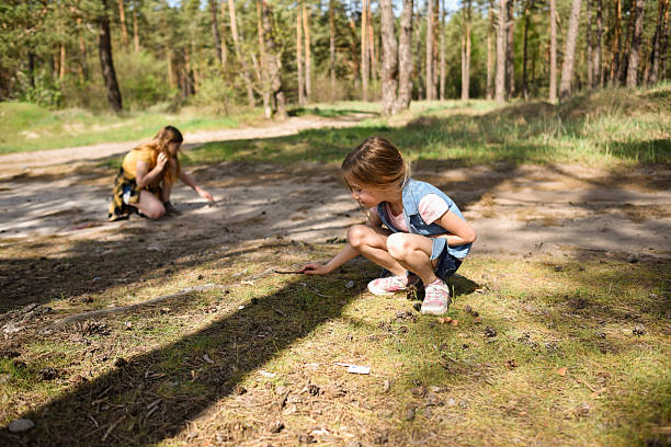 istock Two school-age girls playing on a path in a pine forest 2227355046