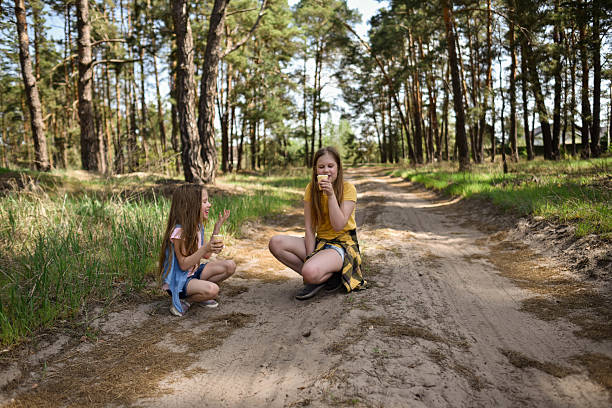 Boy and girl siblings smiling, laughing, and sharing a moment together outdoors.