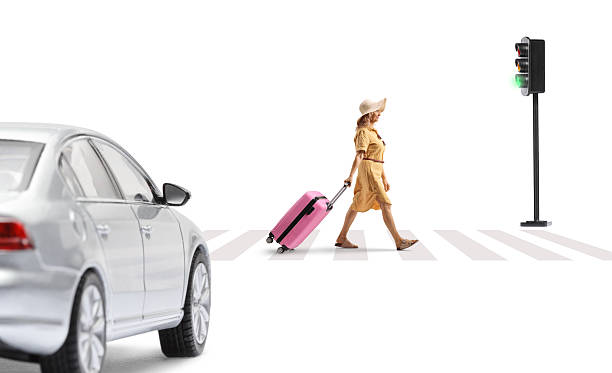 istock Woman walking and pulling a pink suitcase at zebra crossing 2227355142