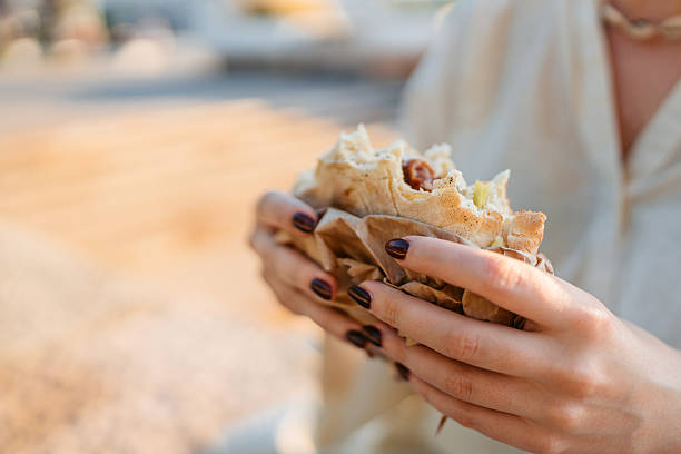 Young Woman Eating A Burger On The Quayside