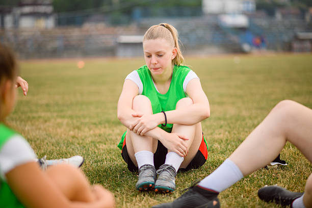 istock Young female soccer player resting after training on the field 2227359574