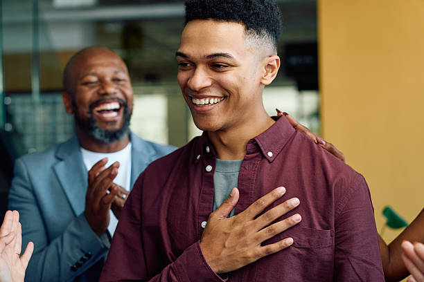 istock Grateful young male professional smiling while being applauded by colleagues in office 2227360340