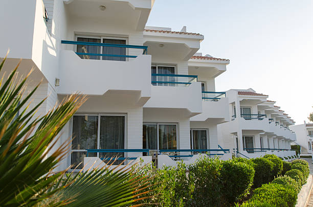 istock Sunlit modern resort with white facade and greenery 2227363638