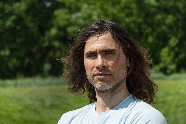istock Thoughtful handsome brunette man with long hair in nature 2227367336