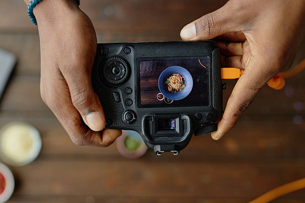 istock Man Photographing Gourmet Pasta Dish with Professional Camera 2227368967