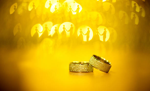 Elegant wedding rings for the bride and groom on a black background with highlights, macro, selective focus