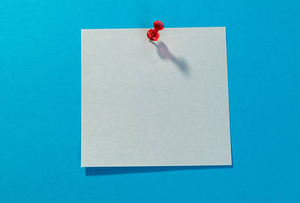 istock Blank white sticky note and red thumbtack on blue background 2227371147