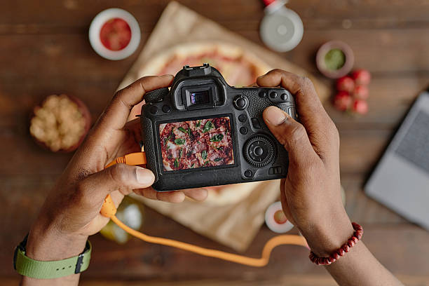 istock Man Photographing Pizza with Professional Camera Overhead 2227371369