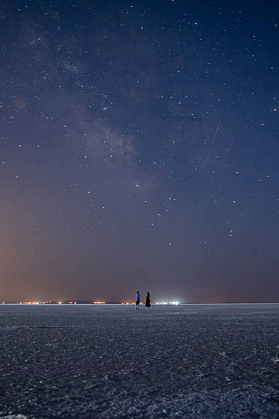 istock Our Milky Way galaxy shining on a dark night and a couple standing under it watching it 2227372462