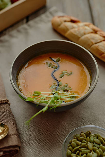 istock Pumpkin Soup Garnished with Microgreens and Pumpkin Seeds on Rustic Table 2227374543