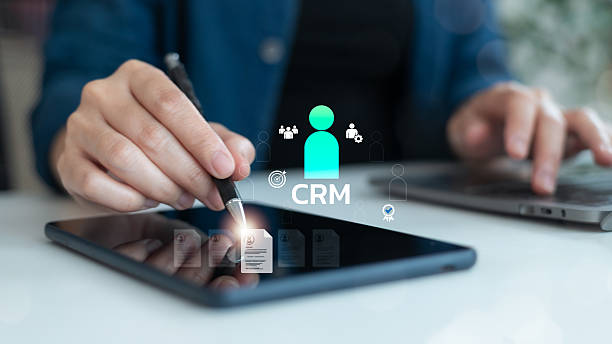 istock Close-up of a business hand using a digital tablet with CRM interface, symbolizing customer relationship management, client data, marketing automation, and digital business tools. 2227378996