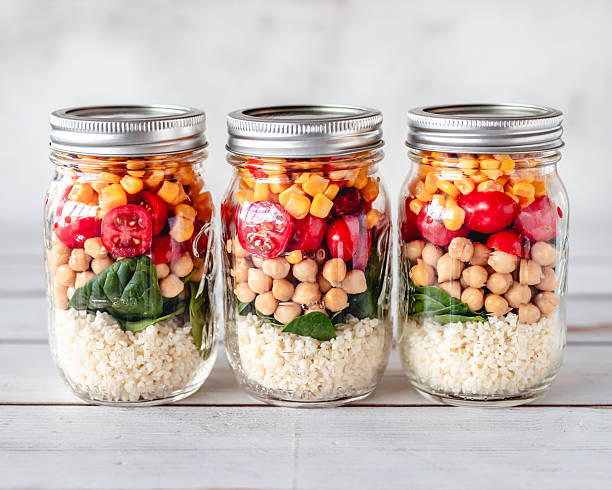 Three salad jars filled with millet, chickpeas and veggies