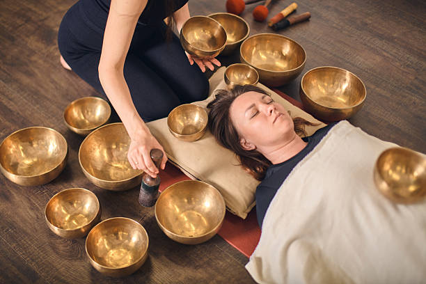 istock Singing bowl therapy session with relaxed woman 2227383138