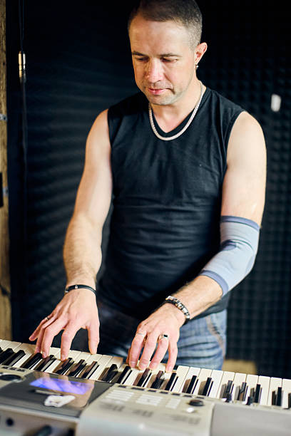 istock Focused musician at keyboard during band rehearsal 2227383189