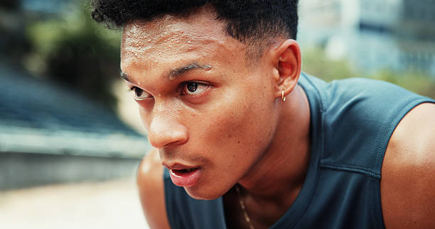istock Runner, man and tired with sweating at stadium for running fatigue, endurance challenge and race competition. Fitness, athlete and exhausted with breathing for exercise recovery, workout and resting 2227383665