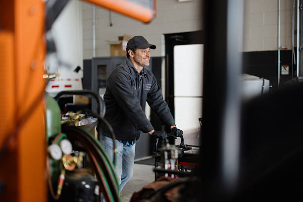 istock Mechanic pushing a cart in a workshop smiling 2227385884