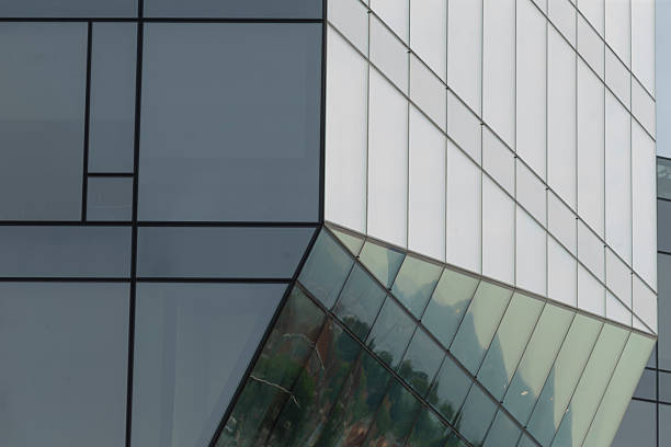 This is a closeup view of a contemporary, modern building featuring a significant number of windows that allows for ample natural light