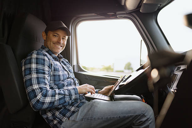 istock Truck driver working on laptop inside cabin 2227389382