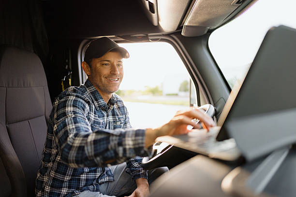 istock Truck driver using tablet while driving delivery truck 2227389394