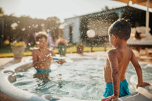 istock Young brothers enjoy a summer day splashing in the pool while having fun in the backyard 2227390774