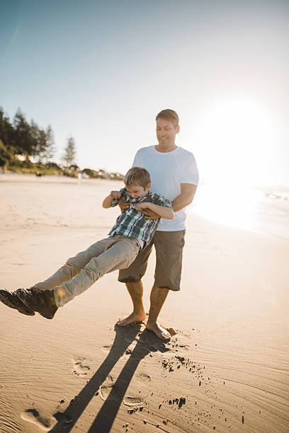 istock dad playing with the son on the beach 2227391411