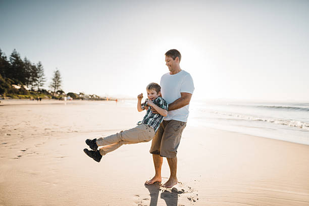 istock dad playing with the son on the beach 2227391441