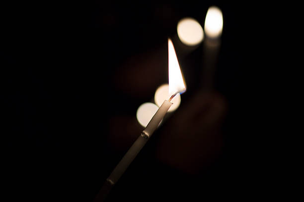 istock A person is holding a lit candle in their hand while in the dark 2227395227