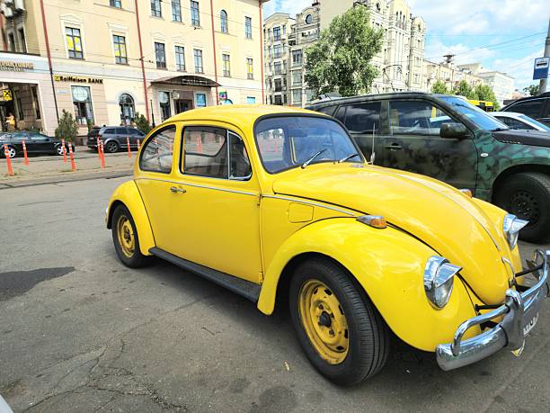 Kyiv, Ukraine - July 23 2025: old yellow classic Volkswagen Beetle parked on street
