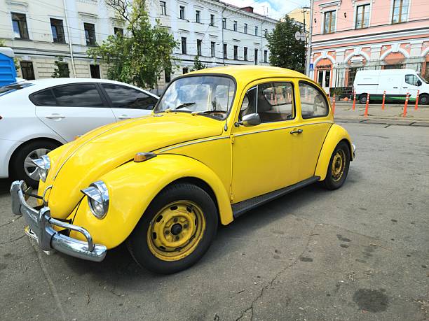Kyiv, Ukraine - July 23 2025: old yellow classic Volkswagen Beetle parked on street