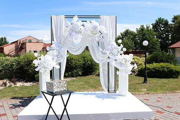 istock Beautiful white fabric arch decorated with white flowers. Wedding ceremony. 2227401501