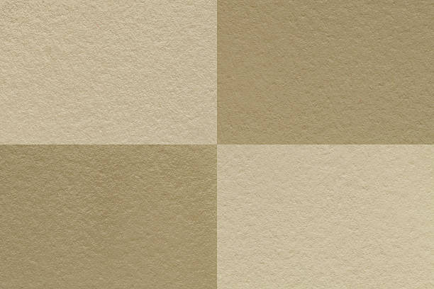 Texture of craft beige and brown paper background with cells pattern, macro. Structure of vintage dense kraft sand cardboard. Felt abstract checkered backdrop closeup.