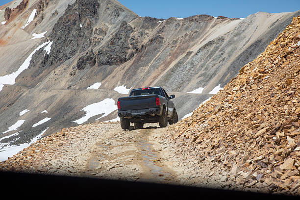 istock Pick-up truck drives through high mountain pass 2227404474