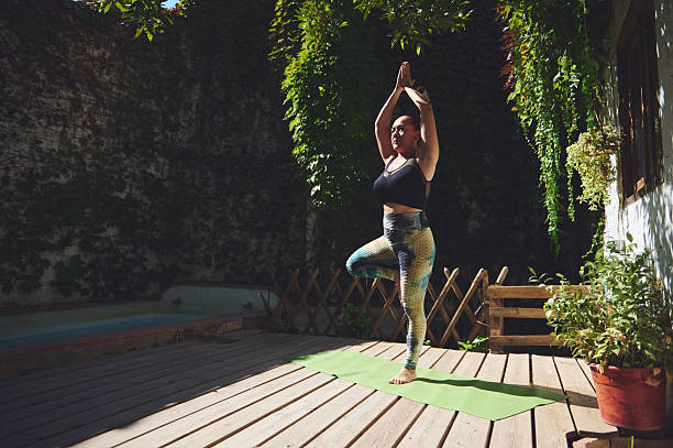 istock Woman Practicing Yoga Outdoors in a Tranquil Garden Setting 2227405069