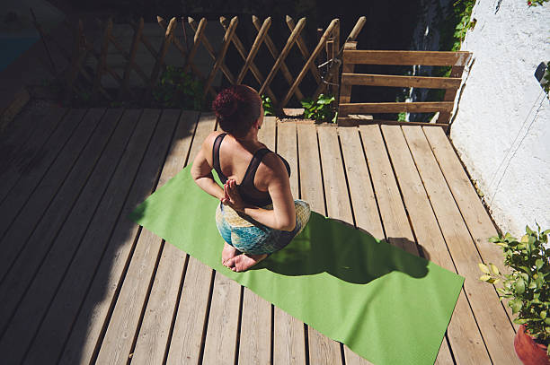 istock Peaceful Woman Practicing Yoga Outdoors on Green Mat During Daytime 2227405119