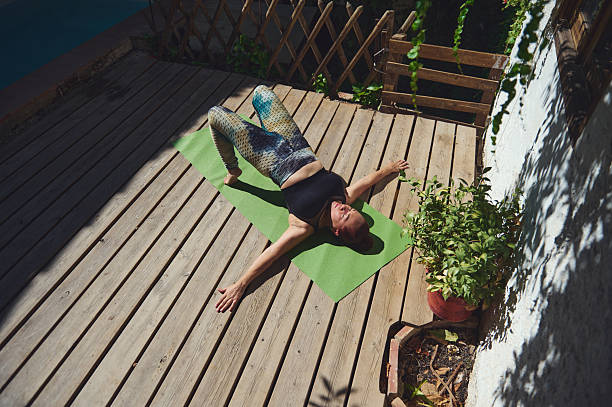 istock Woman Practicing Yoga Outdoors on a Wooden Deck with Sunlight and Greenery 2227405202