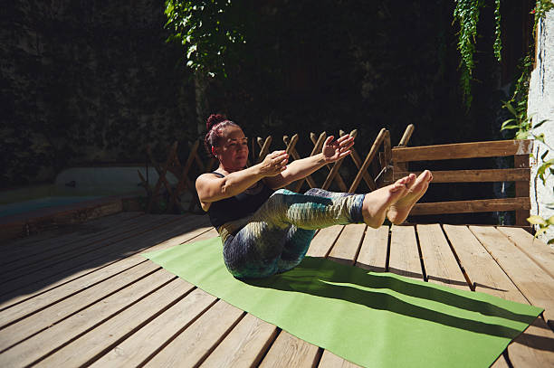 istock Woman Practicing Yoga Outdoors on Wooden Deck in Natural Setting 2227405245