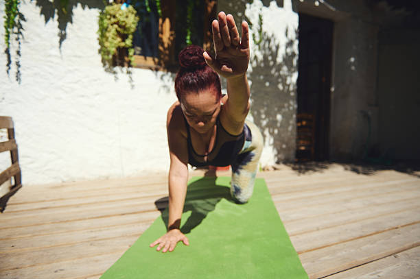 istock Woman Practicing Yoga Outdoors on a Wooden Deck Under Natural Sunlight 2227405844