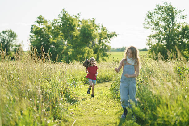 istock Children Running Along Grass Path in Sunny Countryside Landscape 2227407340