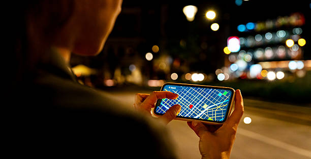 istock Woman using digital map app on smartphone while walking in city at night 2227407594