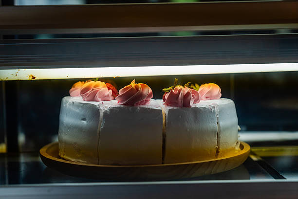 A close-up view of a beautifully crafted layered cake featuring soft icing swirls on top, perfectly designed for any celebratory occasion or dessert table.