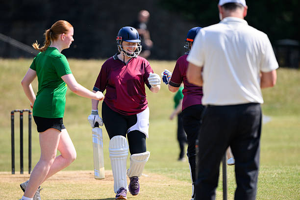 istock Batsmen fist bump changing ends after innings with referee taking notes and fielder crossing the pitch 2227410901