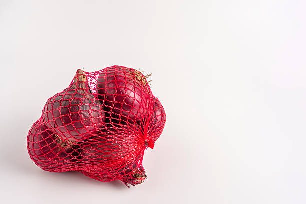 istock Fresh red onions in a red net bag on white background 2227411455