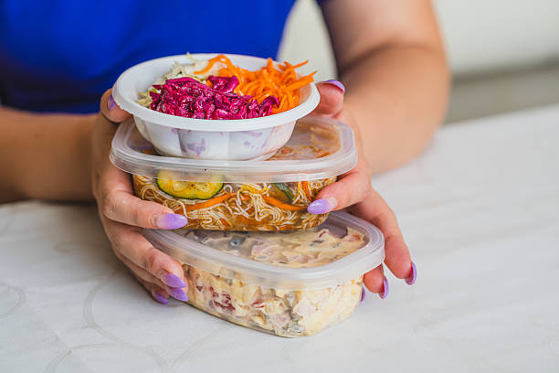 istock Hands with painted nails hold three stacked containers filled with vibrant salads and ingredients The setting is casual and well-lit suggesting a healthy lifestyle 2227414030