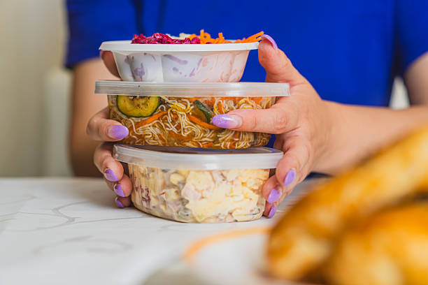 istock Hands with painted nails hold three stacked containers filled with vibrant salads and ingredients The setting is casual and well-lit suggesting a healthy lifestyle 2227414070