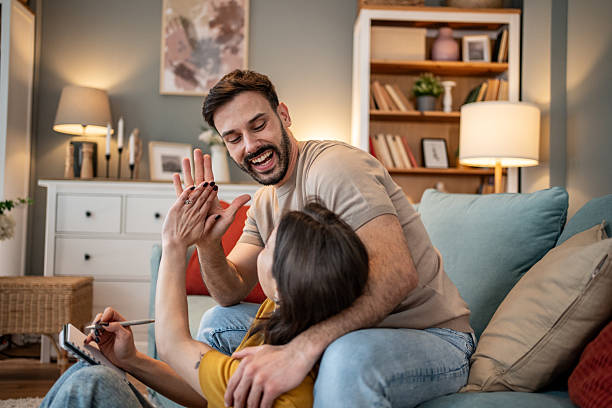 istock Happy couple giving high five while relaxing on sofa at home 2227414943