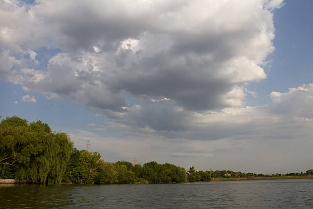 A body of water with trees on the side. Sky. Outdoor. Water. Cloudy. Clouds