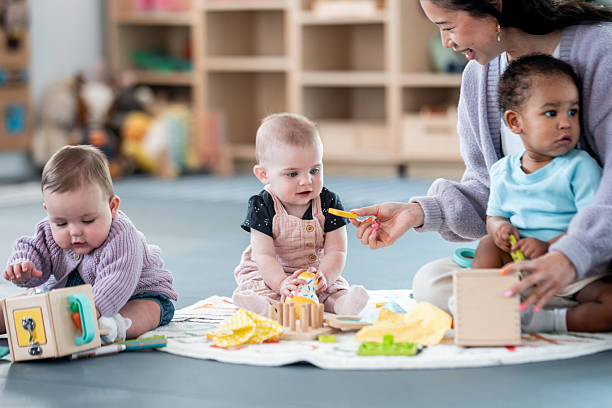 istock Babies and Caregiver Engaged in Play at a Modern Preschool Setting 2227415898