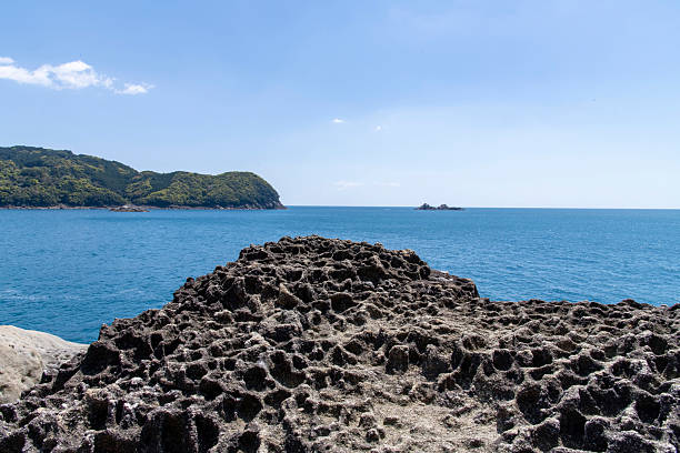Rock formations and cliffs along coastline of Mie Prefecture, Japan in Yoshino Kumano National Park and national natural monument with sign in Japanese: Onigajo Rocks by ministry of Environment